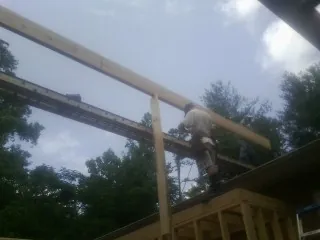 Carpenter setting a ridge beam over a new addition frame — Ice Dam Removal by Roofing Brothers in Harrisonville